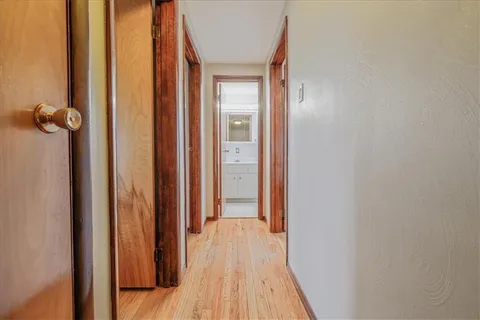 a view of a hallway with wooden floor and closet
