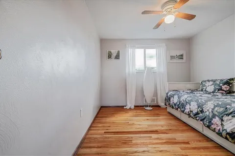 a bedroom with a bed and a chandelier fan