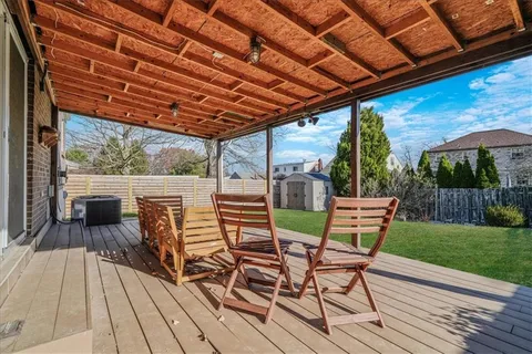 a view of a patio with dining table and chairs with wooden floor and fence