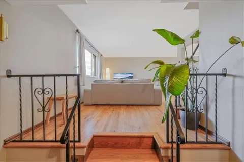 a living room with furniture floor to ceiling window and a potted plant