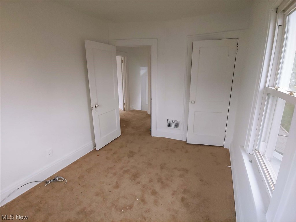 1464 Sherbrook Road Cleveland, OH 44121 - Photo 14 of 15 Unfurnished bedroom featuring light carpet and multiple windows