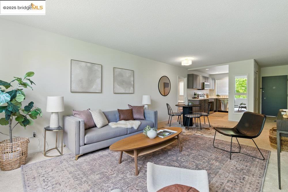 Living room featuring light carpet and a textured ceiling