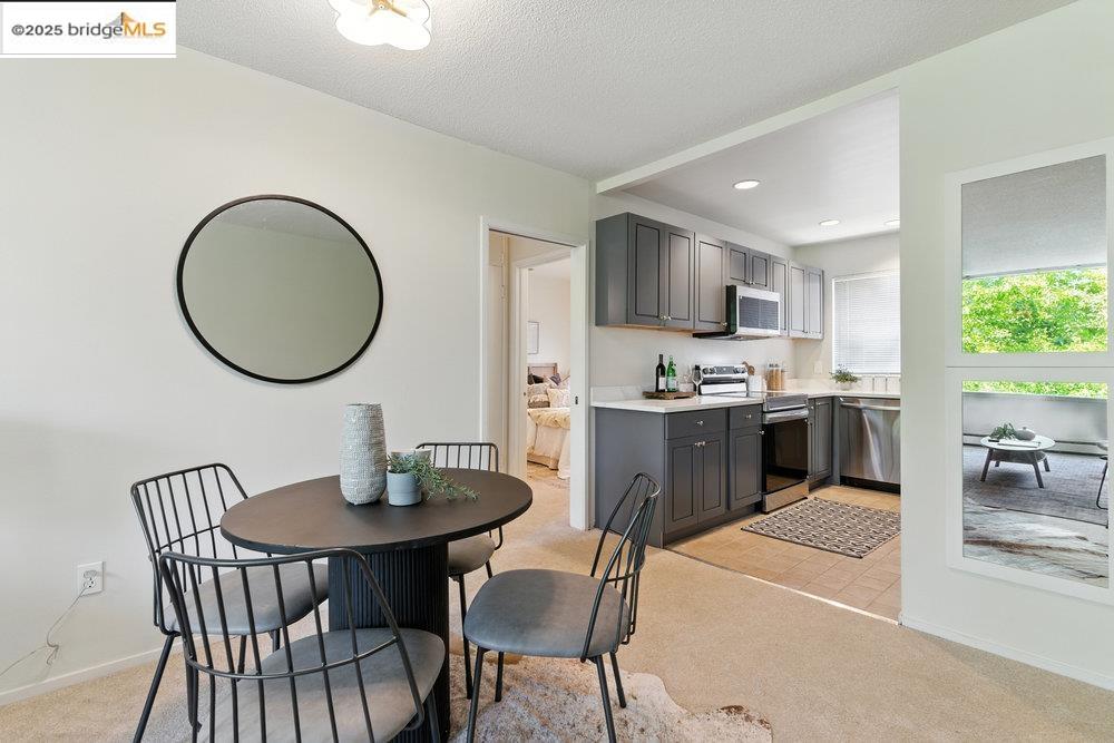 2601 College Avenue, Unit 203 Berkeley, CA 94704 - Photo 15 of 38 Kitchen with light colored carpet, gray cabinets, appliances with stainless steel finishes, light countertops, and recessed lighting