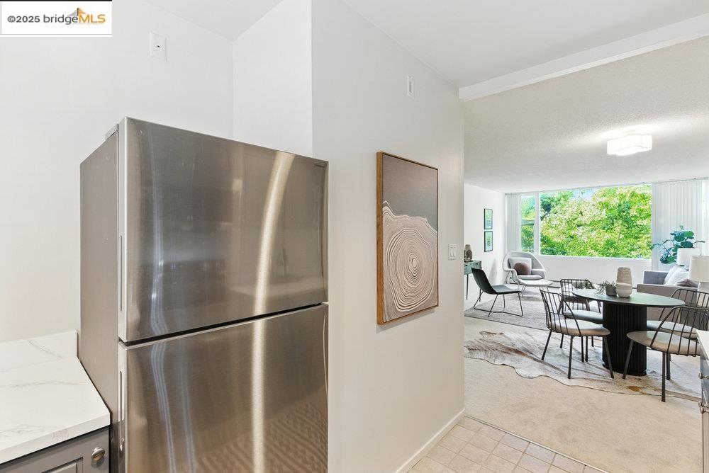 2601 College Avenue, Unit 203 Berkeley, CA 94704 - Photo 20 of 38 Kitchen featuring freestanding refrigerator, light carpet, light stone counters, and light tile patterned floors