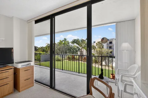 a large hall with stainless steel appliances granite countertop a rug stove and white cabinets
