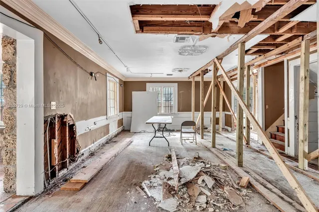 a dining room with wooden floor and windows