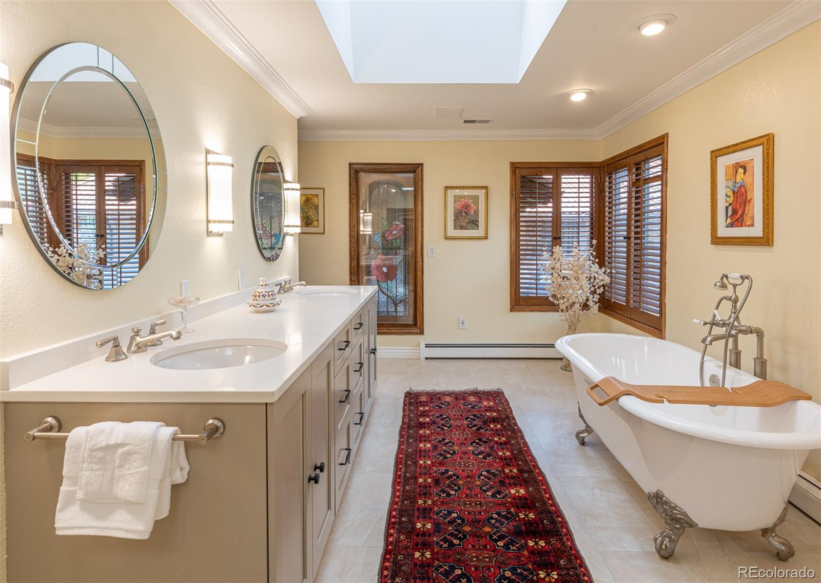 3942 South Pinehurst Circle Denver, CO 80235 - Photo 17 of 25 a spacious bathroom with a double vanity sink a mirror and a bathtub