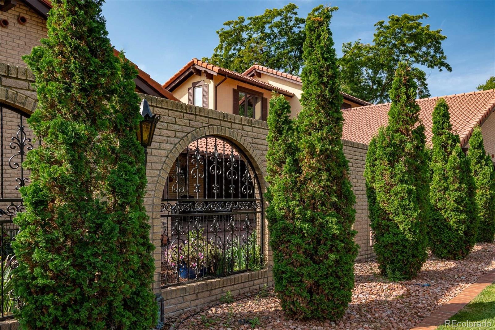 3942 South Pinehurst Circle Denver, CO 80235 - Photo 22 of 25 a front view of a house with garden