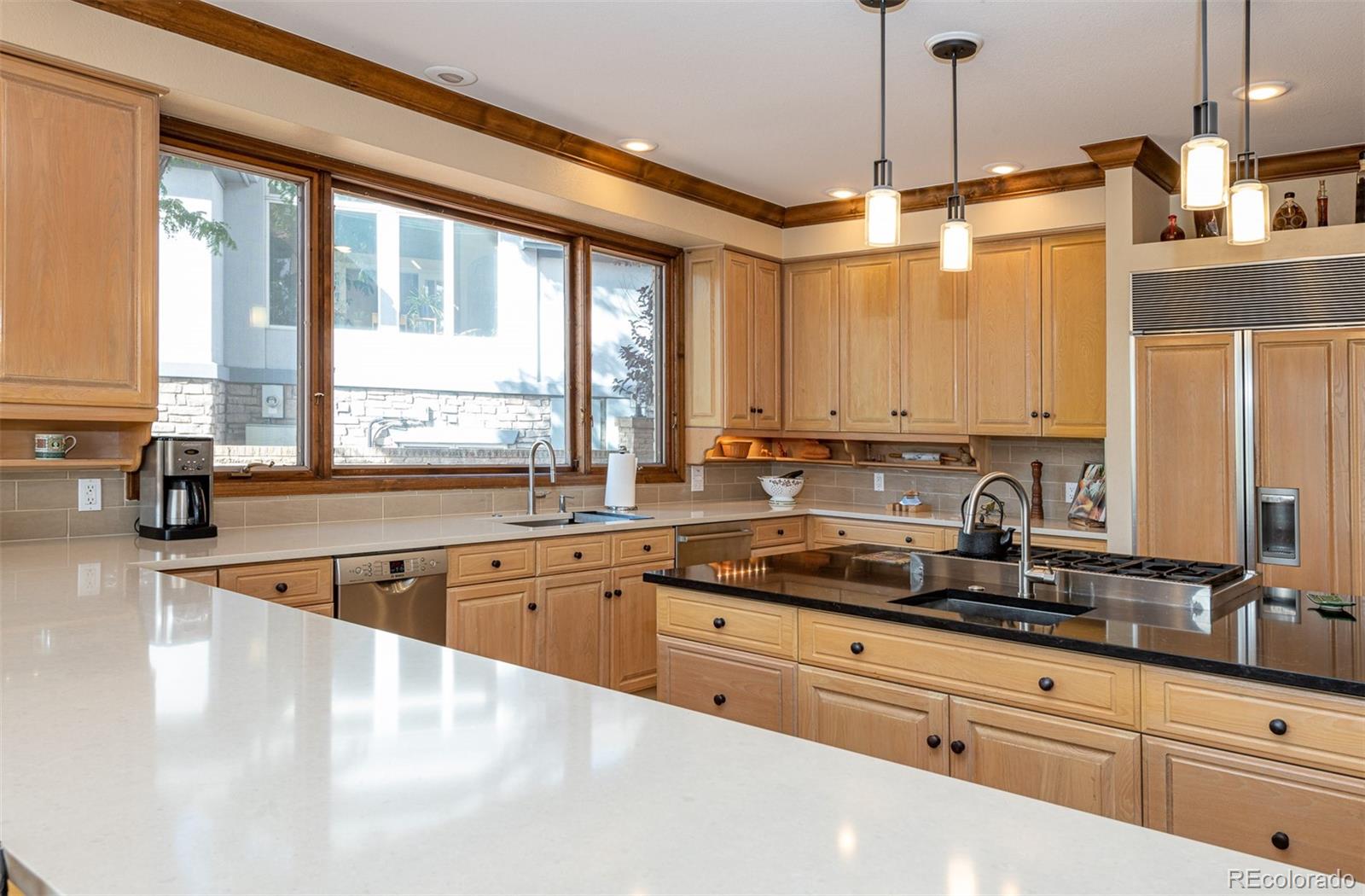 3942 South Pinehurst Circle Denver, CO 80235 - Photo 8 of 25 a kitchen with stainless steel appliances granite countertop a sink a stove and a granite counter tops with a large window
