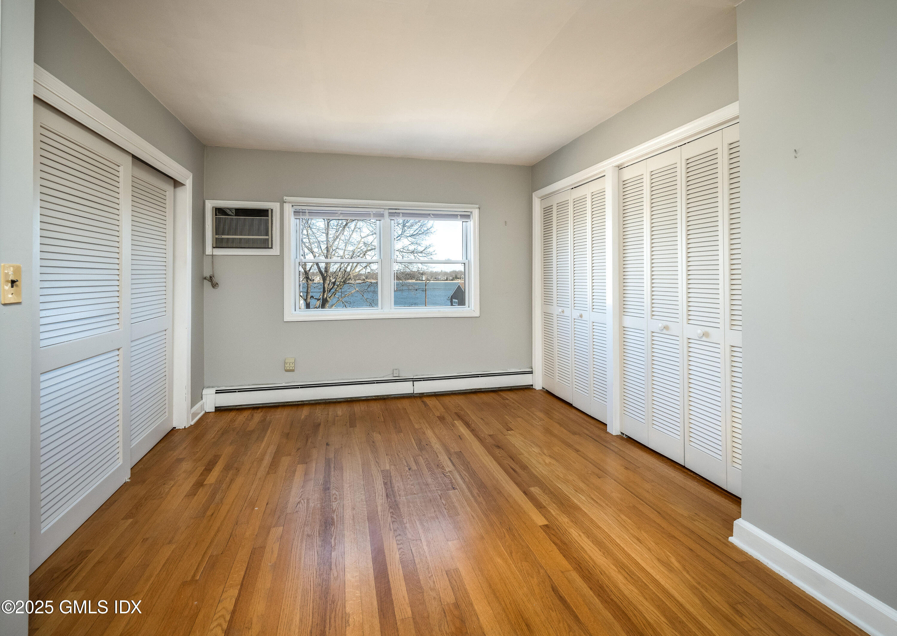 46 Cambridge Road Stamford, CT 06902 - Photo 18 of 29 an empty room with wooden floor and windows