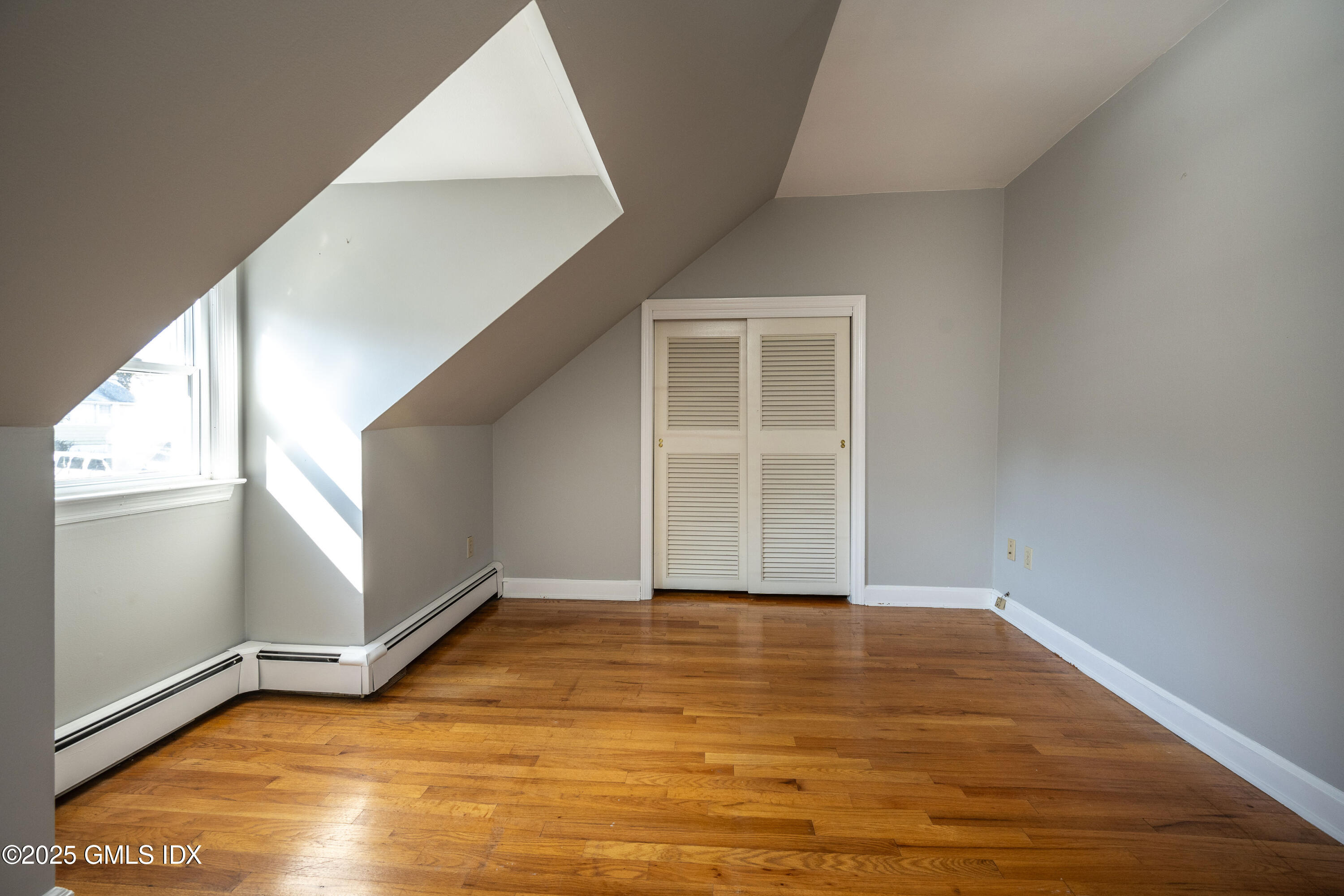 46 Cambridge Road Stamford, CT 06902 - Photo 24 of 29 an empty room with wooden floor and windows