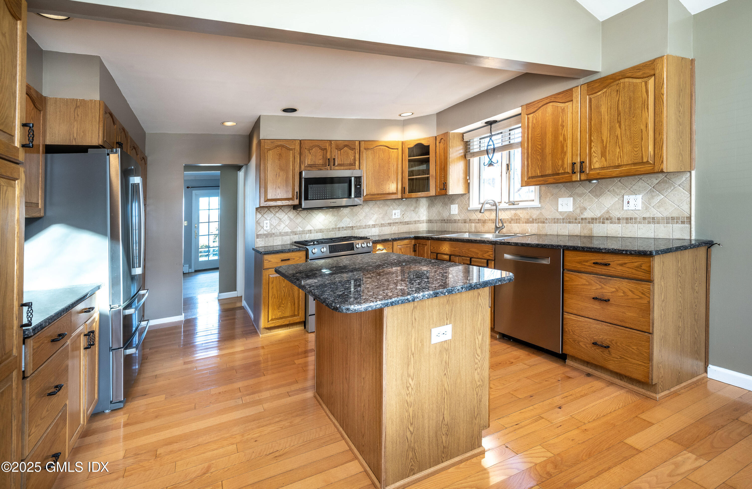 46 Cambridge Road Stamford, CT 06902 - Photo 8 of 29 a kitchen with stainless steel appliances granite countertop a stove a sink and a microwave