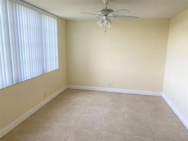 an empty room with a ceiling fan and a window