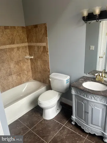a bathroom with a granite countertop toilet a sink and bathtub