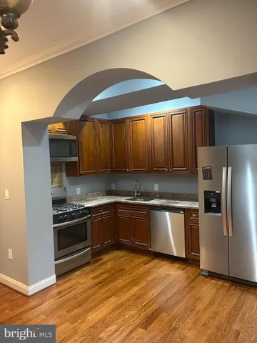 a kitchen with stainless steel appliances granite countertop a stove a sink and a refrigerator