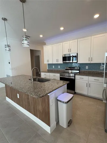a kitchen with stainless steel appliances granite countertop a sink a stove and a refrigerator