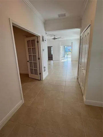 a view of a hallway with wooden floor and cabinet