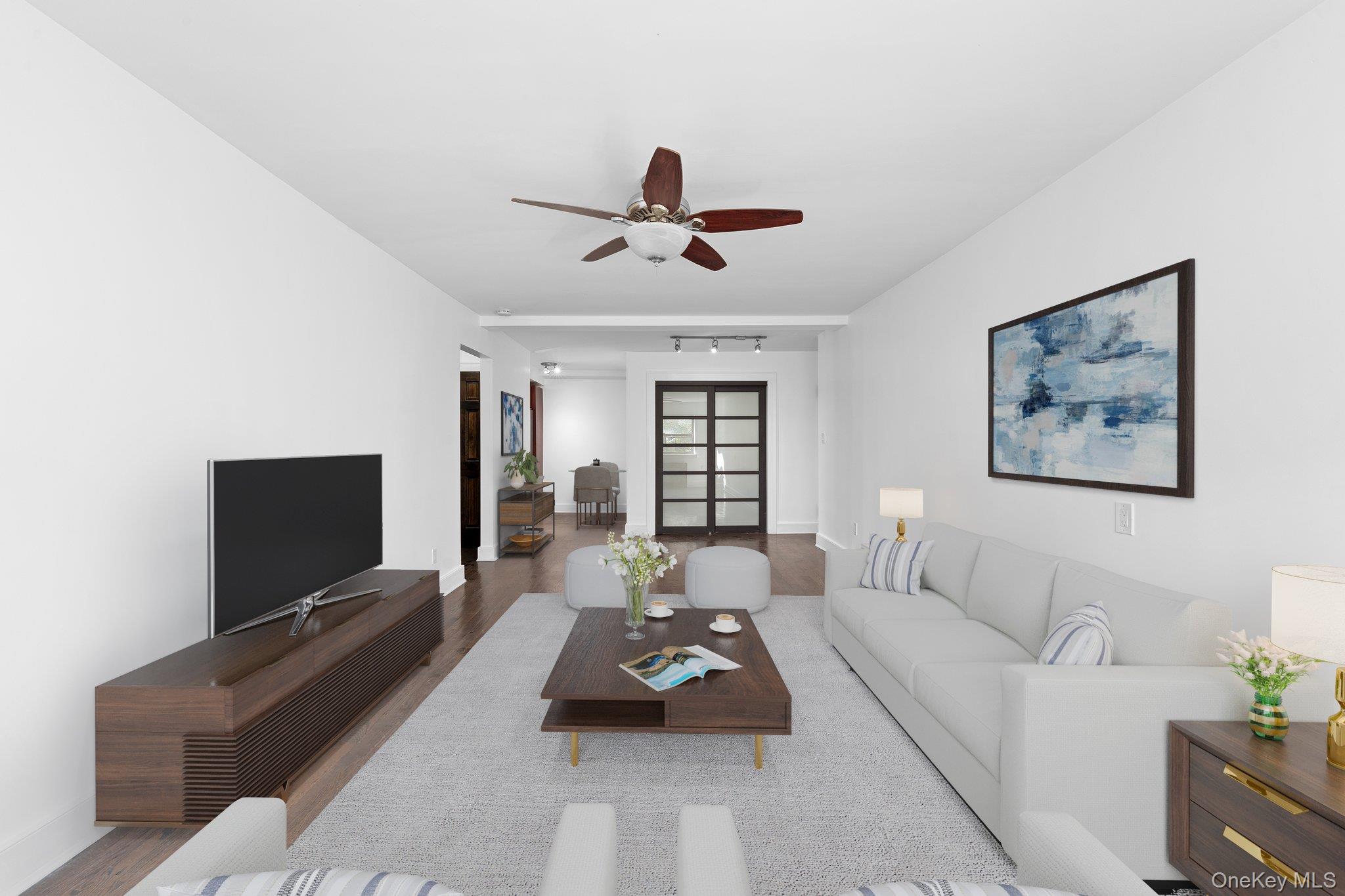 2545 Sedgwick Avenue, Unit 4H Bronx, NY 10468 - Photo 3 of 10 a living room with furniture a ceiling fan and a flat screen tv