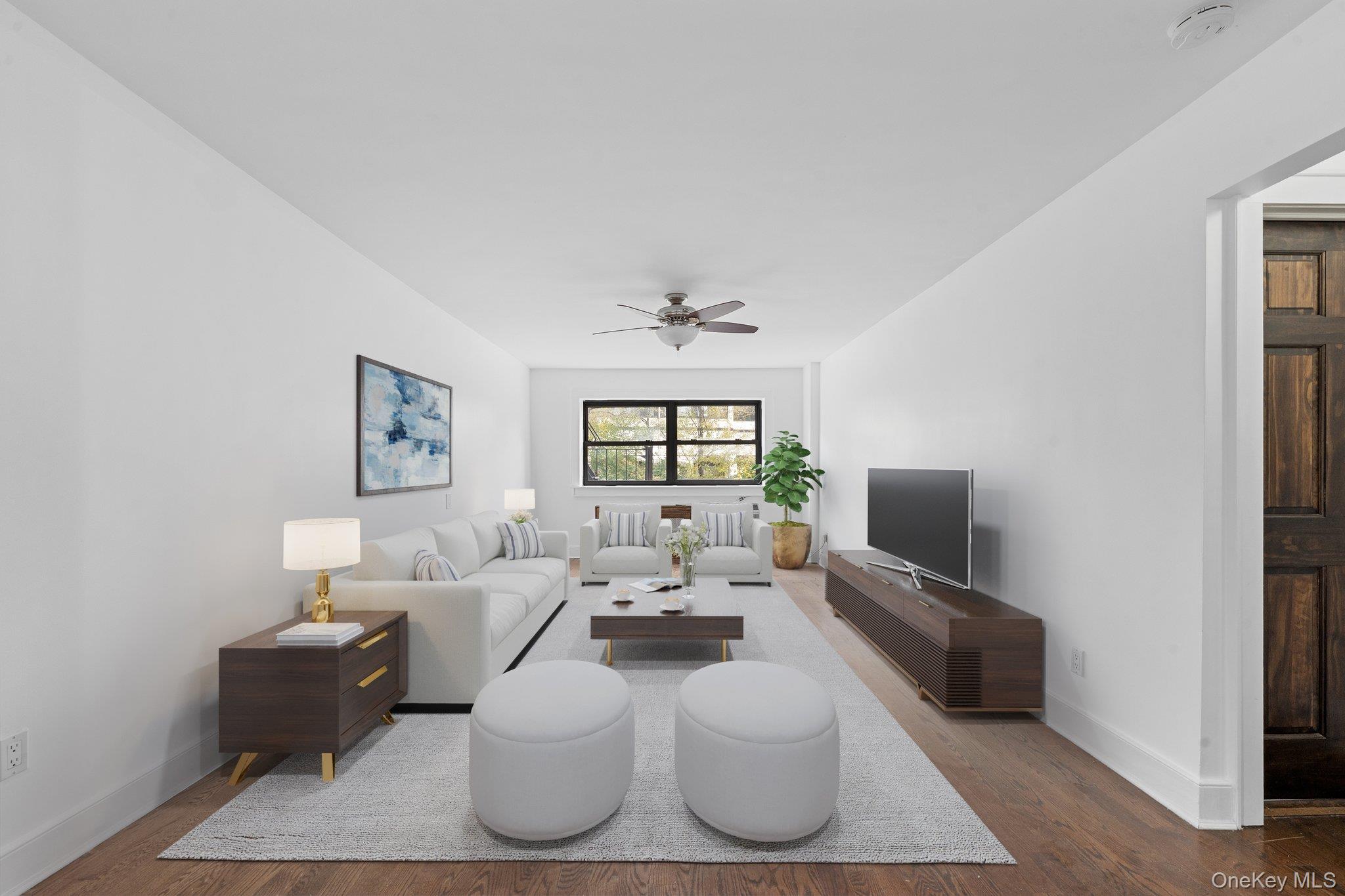 2545 Sedgwick Avenue, Unit 4H Bronx, NY 10468 - Photo 5 of 10 a living room with furniture a flat screen tv and a window