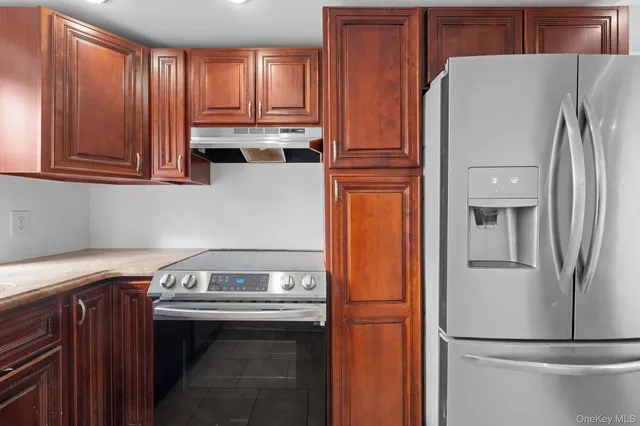 a kitchen with stainless steel appliances granite countertop a refrigerator a stove and a sink with cabinets