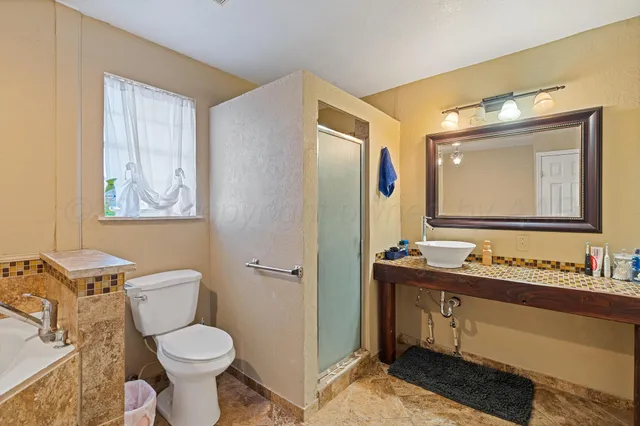 a bathroom with a toilet sink double vanity and mirror