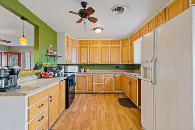 a kitchen with a sink appliances cabinets and a large window