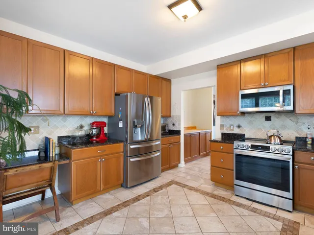 a kitchen with stainless steel appliances wooden cabinets and a stove top oven