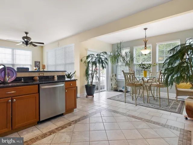 a kitchen with granite countertop a stove a sink a dining table and chairs