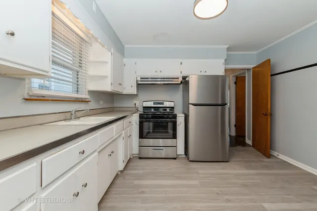a kitchen with stainless steel appliances white cabinets and a refrigerator