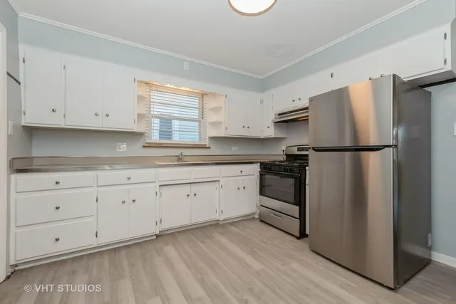 a kitchen with granite countertop white cabinets and a sink
