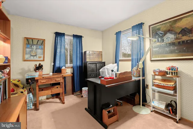 a view of a workspace with furniture and a window