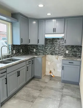 a kitchen with a sink stove and cabinets