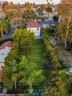 an aerial view of residential houses with outdoor space and trees