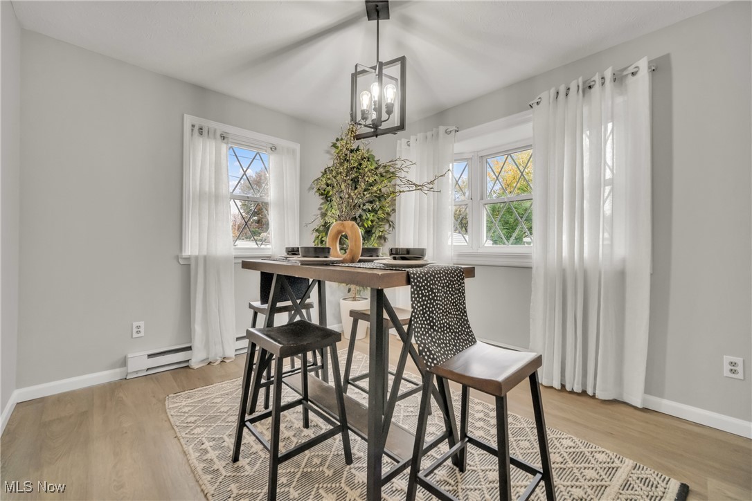 12910 Rockside Road Cleveland, OH 44125 - Photo 10 of 34 Dining room with light hardwood / wood-style flooring, a chandelier, and a baseboard radiator