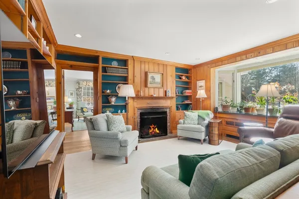 a living room with furniture a fireplace and a large window
