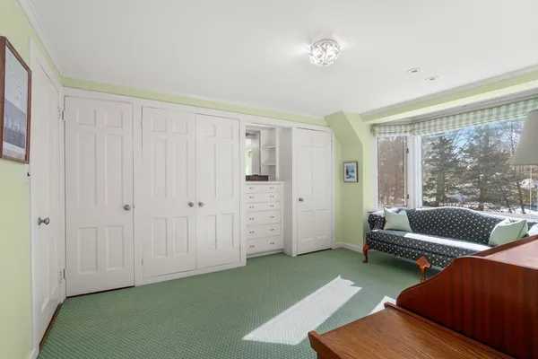 a bedroom with a bed and a dresser next to a window