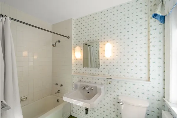 a bathroom with a toilet a sink and a mirror