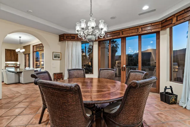 a dining room with furniture a chandelier and window