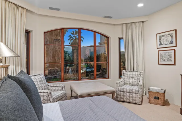 a living room with furniture fireplace and a large window