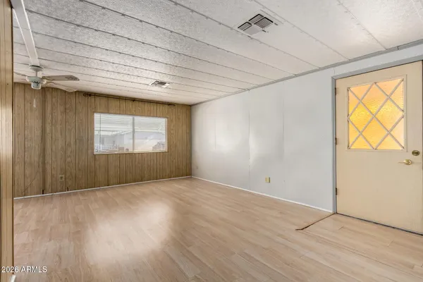 an empty room with wooden floor and windows