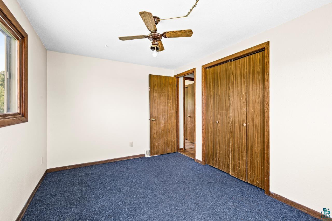 6606 Metso Road Kettle River, MN 55757 - Photo 22 of 84 Room featuring blue carpeting, white walls, and a window with wood-finish trim