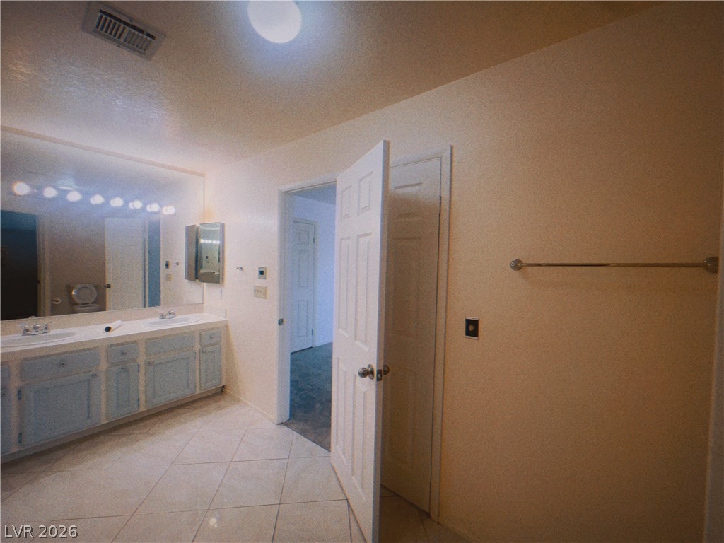 6250 West Flamingo Road, Unit 60 Las Vegas, NV 89103 - Photo 18 of 23 This spacious primary bathroom offers a dual vanity with ample counter space and convenient tile flooring.