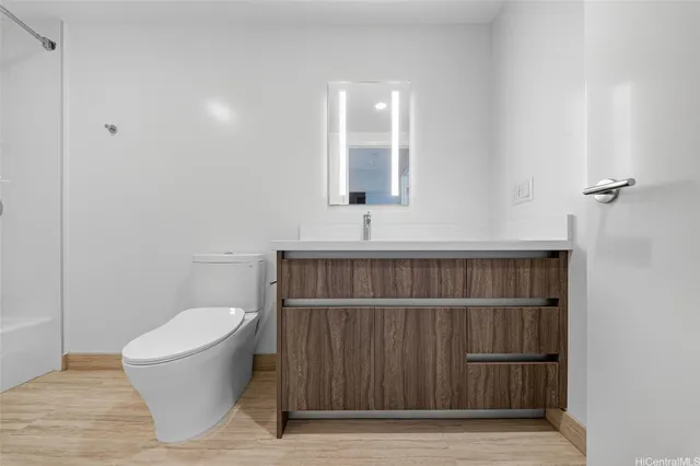 a bathroom with a toilet a sink and mirror