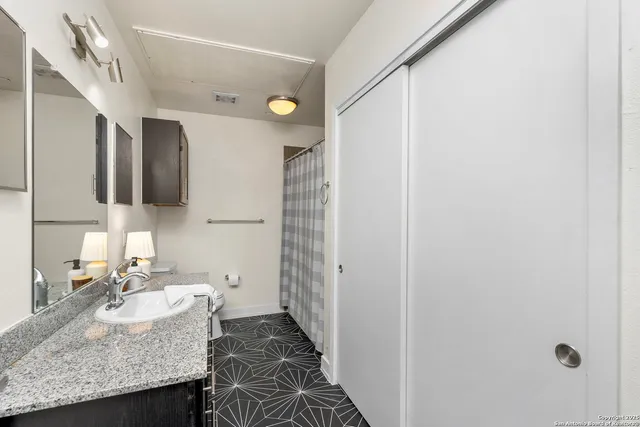 a bathroom with a granite countertop sink toilet and shower