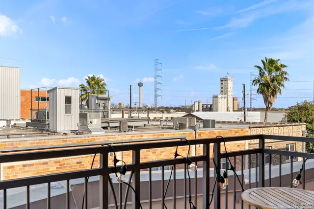 a view of an empty room with wooden floor and a bathroom