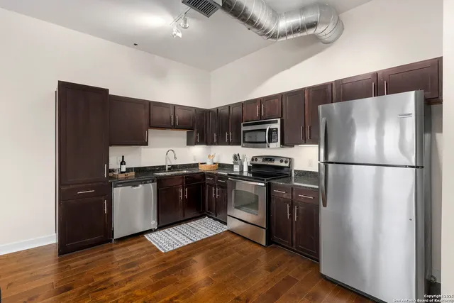 a kitchen with wooden cabinets a stove top oven a sink and dishwasher