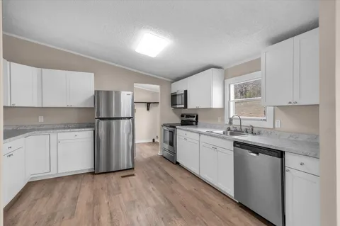 a kitchen with stainless steel appliances granite countertop a sink stove and microwave