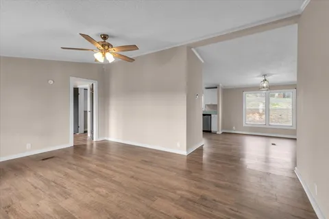 a view of an empty room with a window and a fan