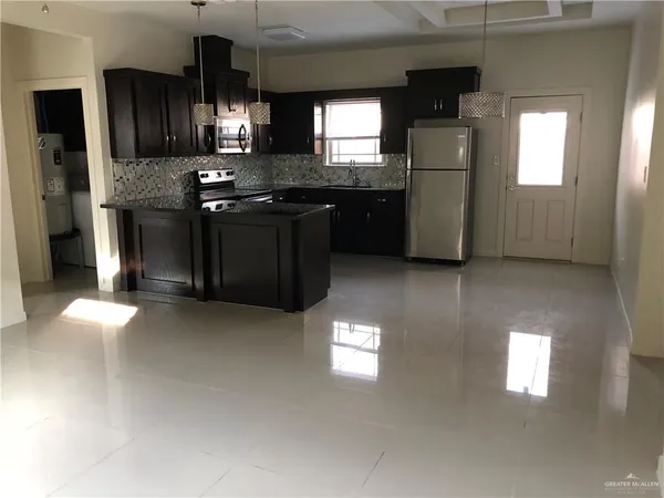 a kitchen with stainless steel appliances granite countertop a stove a sink and a refrigerator