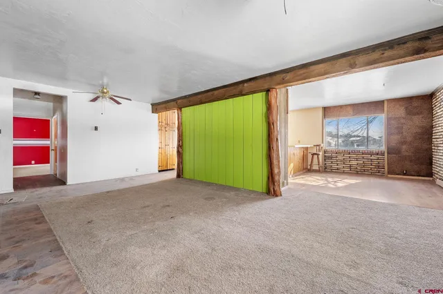 a view of an empty room with a fireplace and a window